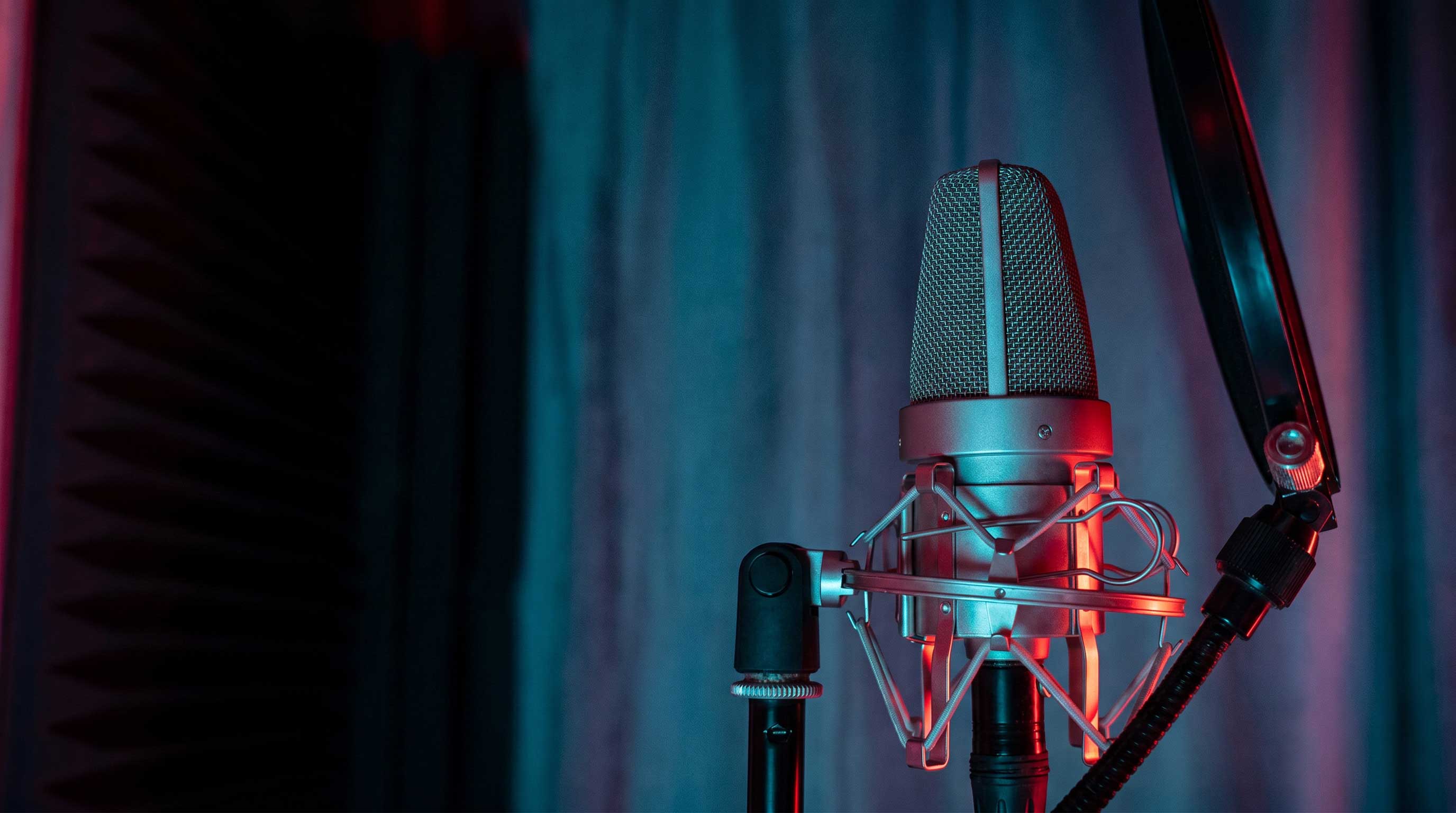 A studio condenser microphone lit in red and blue at Montiago Visual Studios